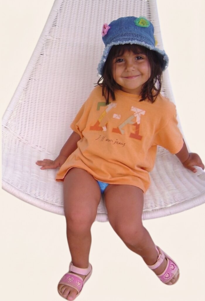 Katerina as a child sitting on a white swing